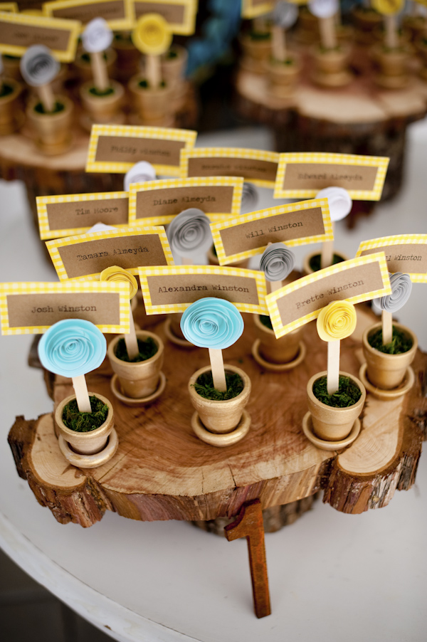 yellow, gray, blue, brown and white flowerpot place cards on a wooden stand- wedding photo by top Atlanta based wedding photographers Scobey Photography